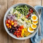 Salade de riz niçoise fraîche et colorée vue de dessus dans un saladier blanc